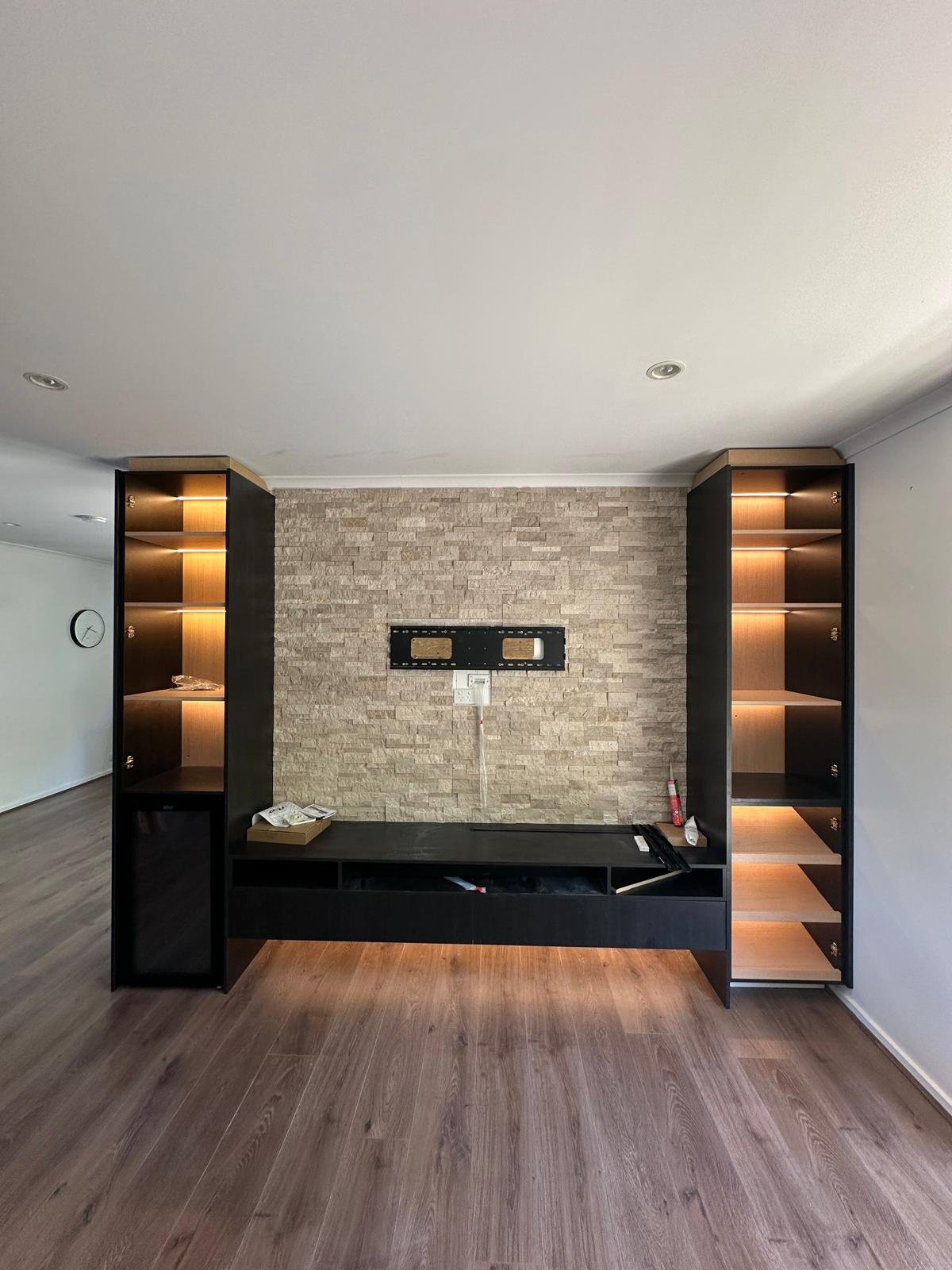 Custom entertainment unit with warm integrated shelf and under-cabinet lighting